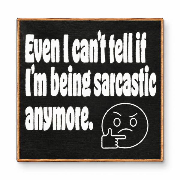 A square black sign with a light wood border, featuring white hand-painted text that reads 'Even I can't tell if I'm being sarcastic anymore.' and a white thinking face emoji with a pointing hand, shown on a white background.