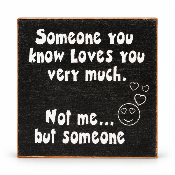 A square decorative sign with a black textured background and a light brown wooden border. White hand-drawn-style text reads, 'Someone you know loves you very much.