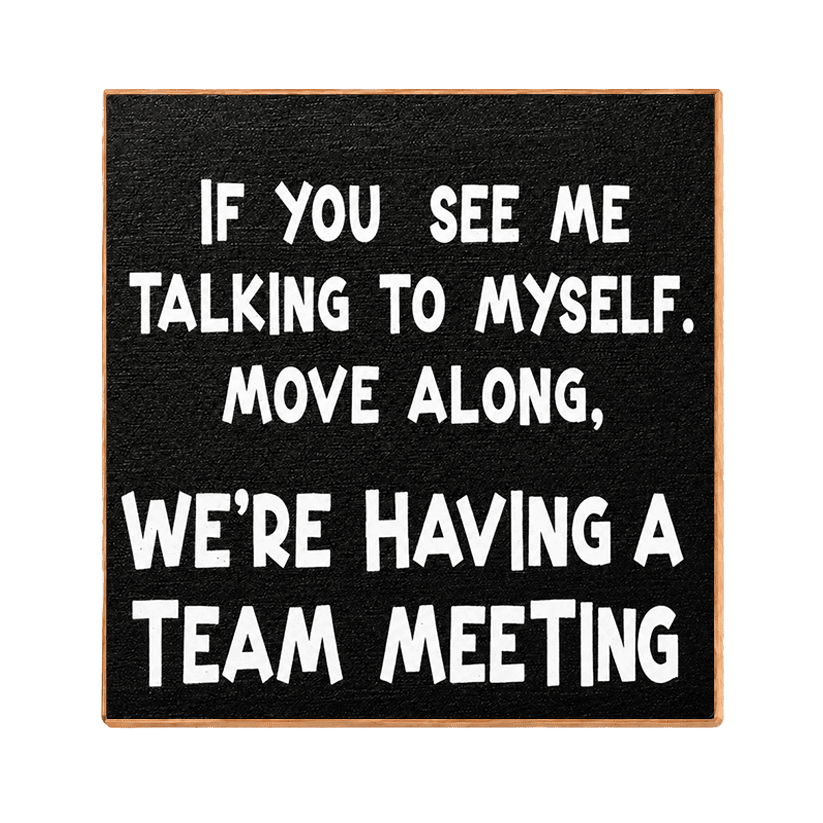 A square black sign with a light wood border and bold white text that reads, 'IF YOU SEE ME TALKING TO MYSELF. MOVE ALONG, WE'RE HAVING A TEAM MEETING.