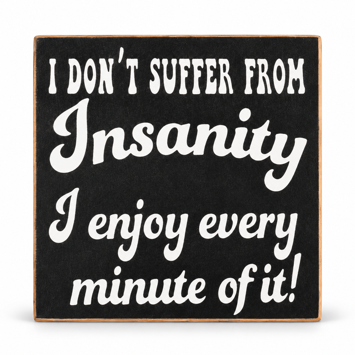 A square black decorative sign with a light wood border and white text that reads, 'I DON'T SUFFER FROM Insanity I enjoy every minute of it!' on a white background.
