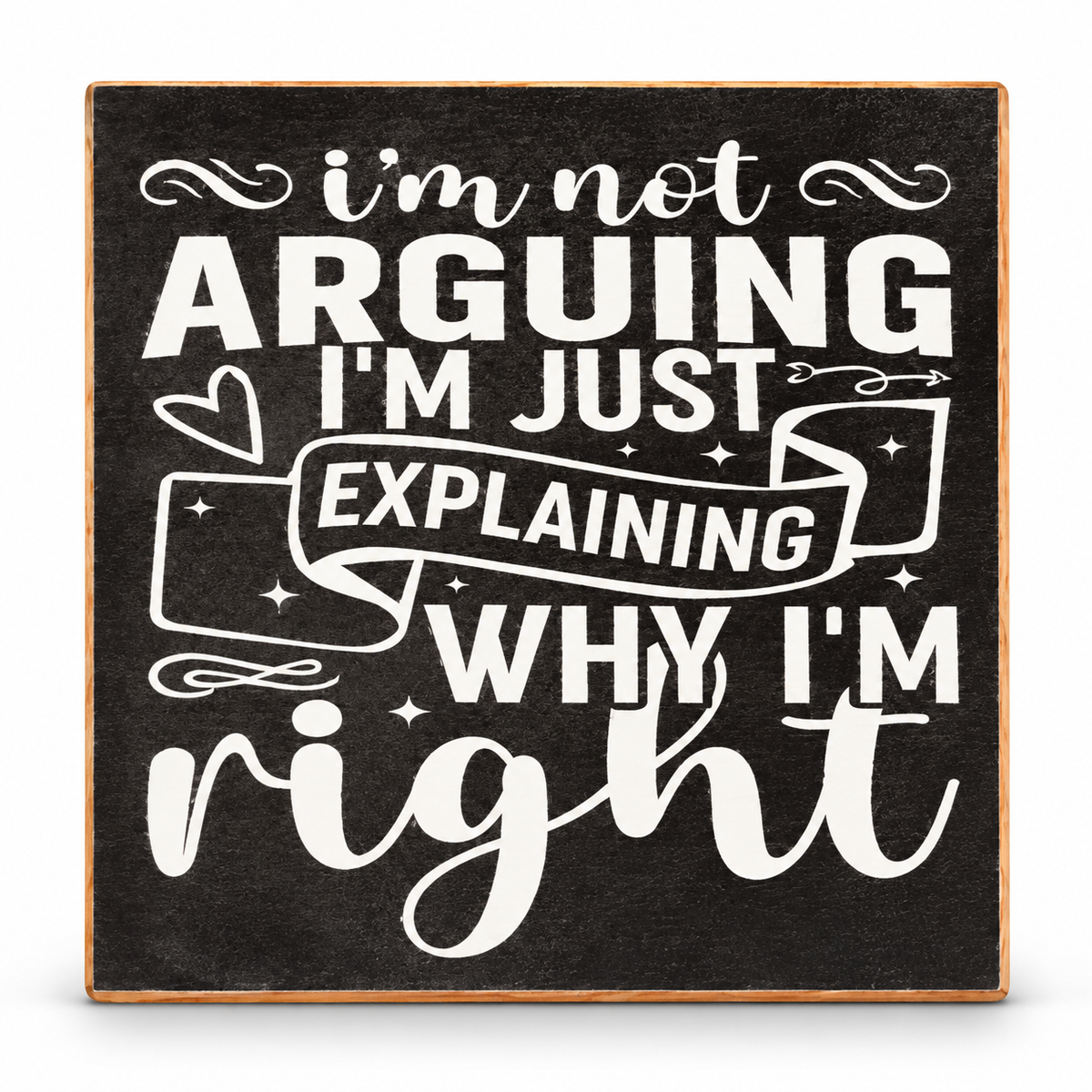 A square decorative sign with a dark charcoal background and white hand-lettered text reading, "i'm not ARGUING I'M JUST EXPLAINING WHY I'M right," with small decorative doodles and stars.