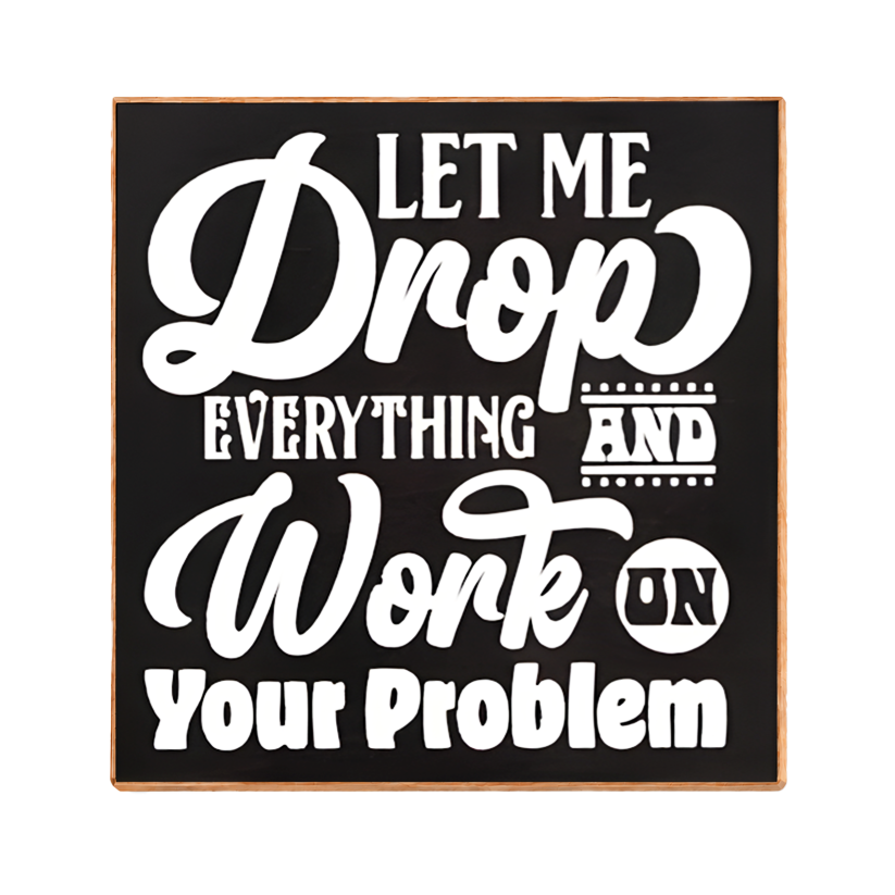 A square decorative sign with a black face and light wood border, featuring white text that reads, 'LET ME Drop EVERYTHING AND Work ON Your Problem.'.