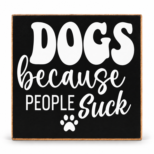 A square decorative sign with a black face, light wood border, and white text reading “DOGS because PEOPLE suck,” plus a small paw print, shown on a white background.