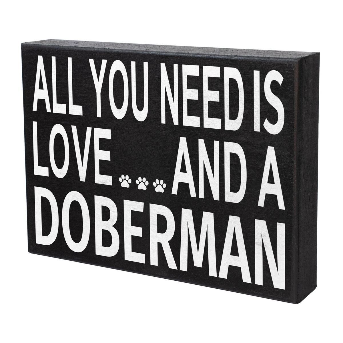 A rectangular black wooden sign with bold white text reading 'ALL YOU NEED IS LOVE.