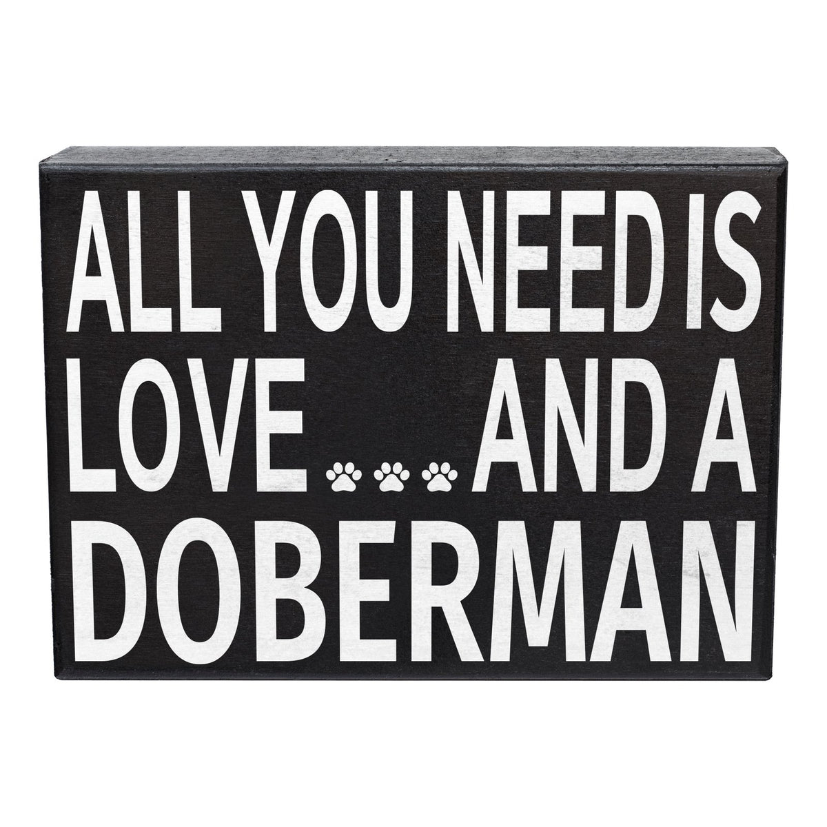 A rectangular black decorative sign with bold white text reading 'ALL YOU NEED IS LOVE.