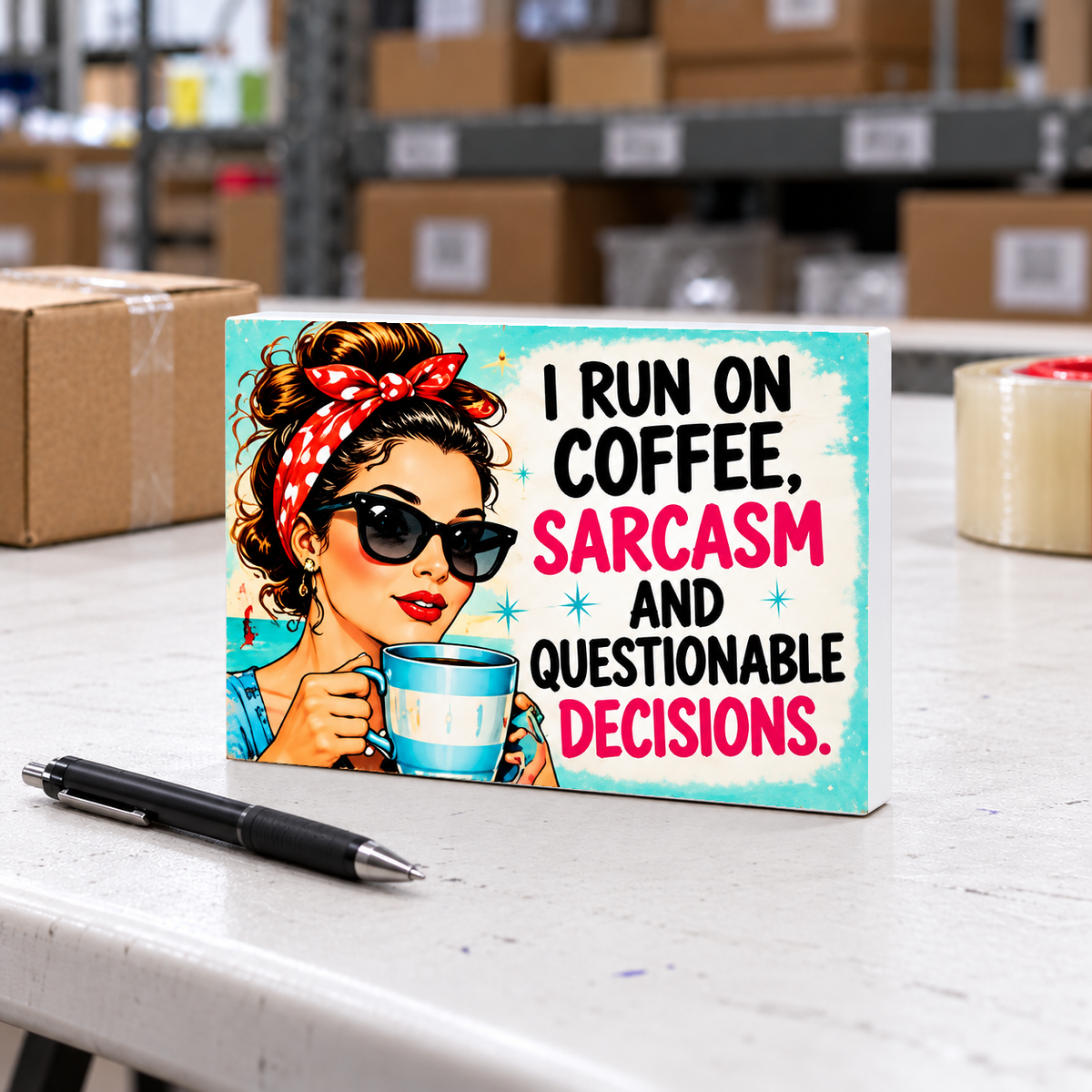 I Run on Coffee, Sarcasm and Questionable Decisions mini sign on a white folding warehouse table with packing supplies.
