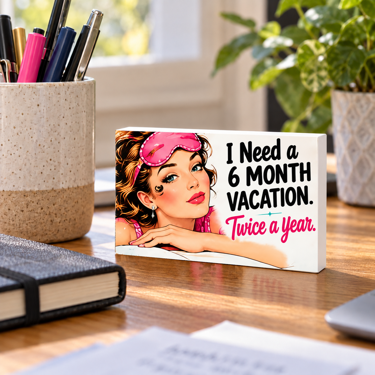 I Need a 6 Month Vacation. Twice a Year mini sign standing on a desk.