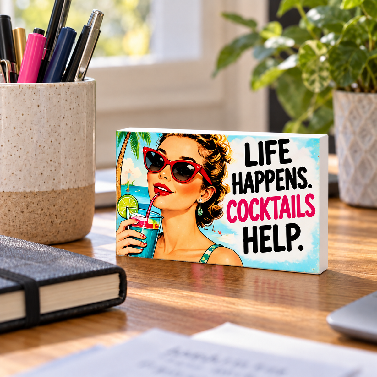 Life Happens. Cocktails Help mini sign standing on a desk with white PVC edges.