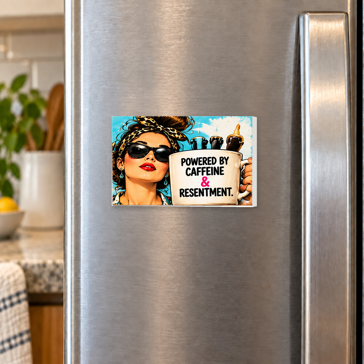 Powered by Caffeine & Resentment rectangular magnet shown front-facing on a refrigerator.