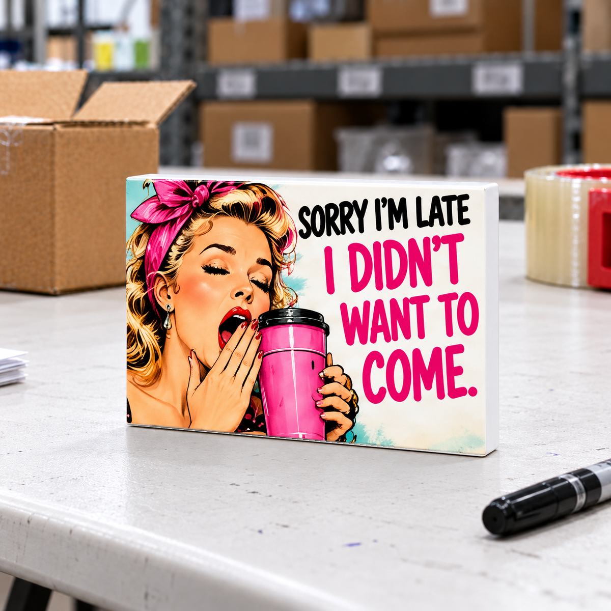Sorry I’m Late I Didn’t Want to Come magnet and mini sign on a white folding warehouse table.