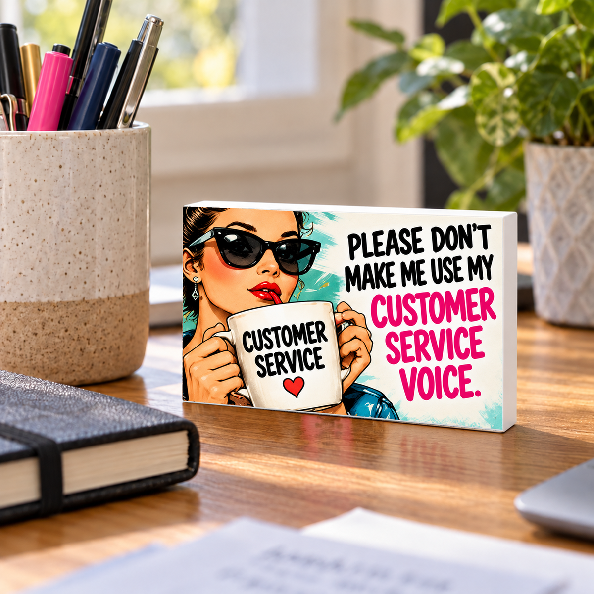 Please Don’t Make Me Use My Customer Service Voice mini sign standing on a desk with white PVC edges.