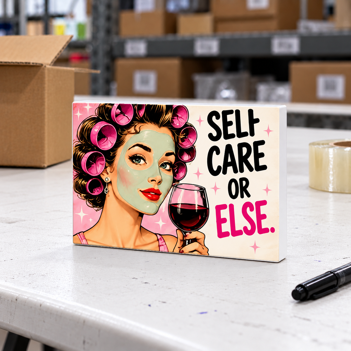 Self Care or Else magnet and mini sign on a white folding warehouse table.