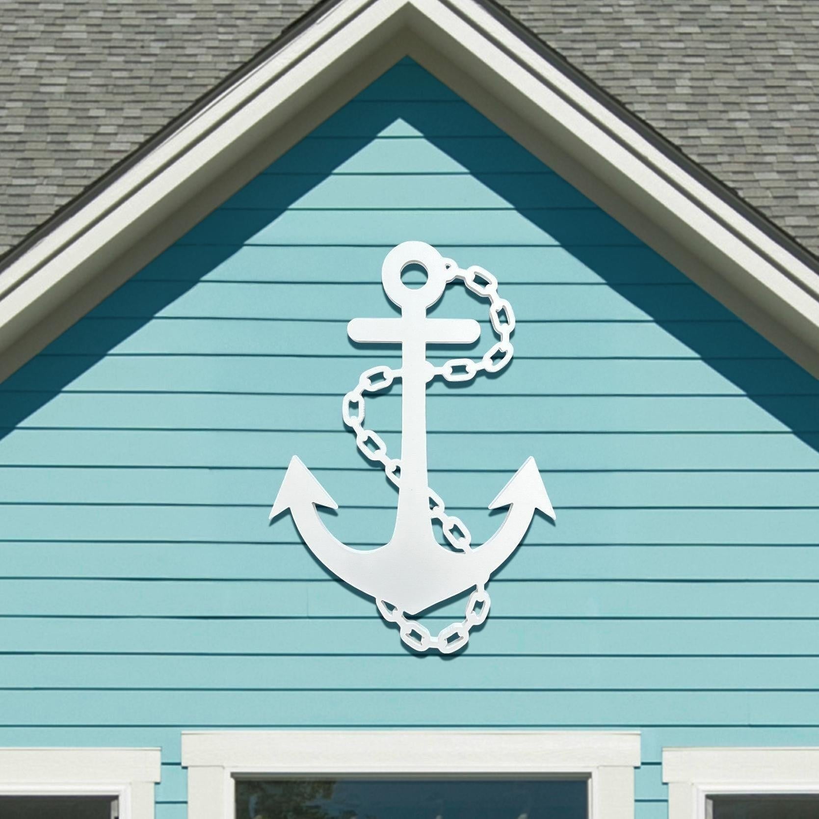 white nautical anchor wall decor mounted on a light blue coastal home exterior